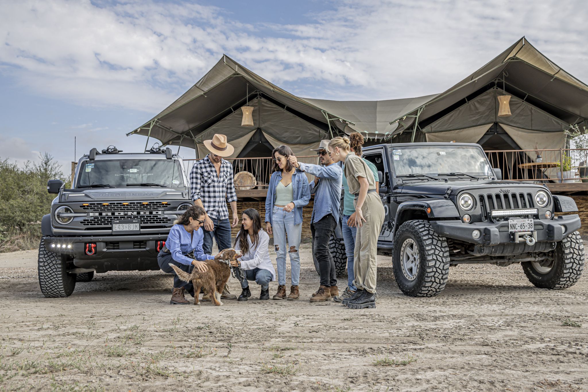 A group of family and friends gathered with their off-road vehicles at a camping site, illustrating year-long adventure and community bonding.
